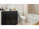 Bathroom with a sleek, dark vanity, granite countertop and a shower featuring gold accents at 2673 Caruso Way, Atlanta, GA 30339