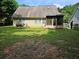 View of the backyard with a lawn, part of an old grill, and the house in the background at 7073 Stonecreek Dr, Douglasville, GA 30134