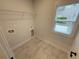 Well-lit laundry room featuring a window, tile flooring, and hookups for a washer and dryer at 72 Hanover Dr, Villa Rica, GA 30180