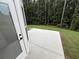 The concrete back patio is surrounded by a grassy lawn and tall trees at 72 Hanover Dr, Villa Rica, GA 30180