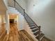 Elegant staircase with hardwood treads, iron balusters, and views into a living room with a fireplace at 72 Hanover Dr, Villa Rica, GA 30180