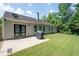 Well-maintained backyard with a patio, grill, lush green grass, and surrounding trees at 784 Crestworth Xing, Powder Springs, GA 30127