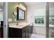 Bathroom featuring a double sink vanity and walk-in shower with natural light from the large window at 784 Crestworth Xing, Powder Springs, GA 30127
