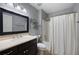 Bathroom features a vanity with dark wood cabinets and an enclosed shower and tub area at 784 Crestworth Xing, Powder Springs, GA 30127