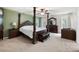 Primary bedroom featuring a four-poster bed, sitting area, and carpet flooring at 784 Crestworth Xing, Powder Springs, GA 30127