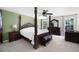 Spacious primary bedroom with a four-poster bed, seating area, and beautiful natural light from the windows at 784 Crestworth Xing, Powder Springs, GA 30127