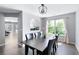 Bright dining room features modern light fixture, dark wood table with seating for six, and large sunlit window at 784 Crestworth Xing, Powder Springs, GA 30127