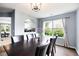 Beautiful dining room with seating for six opens up to kitchen; features modern light fixture and large sunlit window at 784 Crestworth Xing, Powder Springs, GA 30127