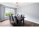 Bright dining room with a modern chandelier, large window, and hardwood floors, perfect for entertaining at 784 Crestworth Xing, Powder Springs, GA 30127