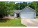 Charming single-story home featuring gray siding, stone accents, manicured lawn, and attached two-car garage at 784 Crestworth Xing, Powder Springs, GA 30127