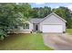 Charming single-story home featuring gray siding, stone accents, manicured lawn, and attached two-car garage at 784 Crestworth Xing, Powder Springs, GA 30127