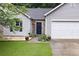 Close-up of home featuring stone accents, a well manicured yard, and a dark front door at 784 Crestworth Xing, Powder Springs, GA 30127