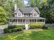 Charming two-story home featuring a welcoming front porch, well-manicured lawn, and lush landscaping at 150 Kensley Way, Dallas, GA 30157