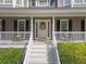 Close up of front porch of the home with chairs, and door with fall-themed wreath at 150 Kensley Way, Dallas, GA 30157