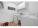 Bright laundry room features a sink, white cabinets, washer, and dryer at 150 Kensley Way, Dallas, GA 30157