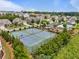 Aerial view of the neighborhood showcasing tennis courts and a community pool surrounded by trees at 4154 Hawking Dr, Suwanee, GA 30024