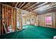 Unfinished basement space with exposed beams, green carpeting, and room to add customized features at 4154 Hawking Dr, Suwanee, GA 30024
