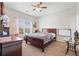 Cozy bedroom featuring a wood bed frame, ceiling fan, and large window with plenty of natural light at 4154 Hawking Dr, Suwanee, GA 30024