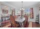 Formal dining room with elegant chandelier, large windows, and decorative curtains at 4154 Hawking Dr, Suwanee, GA 30024