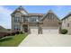 Beautiful brick two-story home with a manicured lawn and a two-car garage at 4154 Hawking Dr, Suwanee, GA 30024