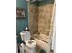 This bathroom features a toilet next to a tub shower with decorative beige tile and blue accent walls at 4164 River Shoals Ct, Duluth, GA 30097