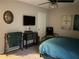 Cozy bedroom with mounted TV and ceiling fan, and a dark colored metal frame bed and interesting wall decor at 4164 River Shoals Ct, Duluth, GA 30097