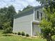 Side view of the house with a white garage door, siding, and well-maintained landscaping at 4164 River Shoals Ct, Duluth, GA 30097