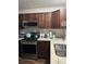 Modern kitchen with granite countertops, stainless steel appliances and dark wood cabinets at 4164 River Shoals Ct, Duluth, GA 30097