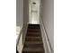 Carpeted staircase with white railings and a view of the hallway leading to a white door at 4164 River Shoals Ct, Duluth, GA 30097