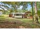Wide shot of the backyard featuring trees and brick exterior and screened in porch at 6000 Malibu Drive Dr, Morrow, GA 30260