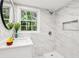 Bathroom featuring marble tile, glass-enclosed shower, new toilet, and a large mirror at 6000 Malibu Drive Dr, Morrow, GA 30260