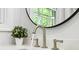 A close-up shot of a modern bathroom faucet on a white countertop, plant decoration at 6000 Malibu Drive Dr, Morrow, GA 30260