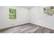 A serene bedroom showcases gray wood flooring, fresh white walls, and well-lit windows providing views of the outdoors at 6000 Malibu Drive Dr, Morrow, GA 30260