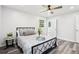 Sunlit bedroom with ceiling fan, gray wood floors and decorative bedside table at 6000 Malibu Drive Dr, Morrow, GA 30260