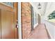 View of the front porch with brick siding, pendant lights, and a secure, modern door lock at 6000 Malibu Drive Dr, Morrow, GA 30260