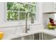 Stainless steel kitchen sink and faucet with water running; view of window and granite countertop at 6000 Malibu Drive Dr, Morrow, GA 30260