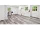 A well-lit kitchenette boasts sleek white cabinetry, modern fixtures, and gray wood flooring, with ample natural light at 6000 Malibu Drive Dr, Morrow, GA 30260