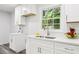 Modern kitchenette featuring bright cabinets, stainless steel faucet, quartz countertops, and natural light from a window at 6000 Malibu Drive Dr, Morrow, GA 30260