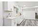 A stylish kitchenette featuring white cabinets, modern countertops, stainless steel fixtures, and wood flooring at 6000 Malibu Drive Dr, Morrow, GA 30260