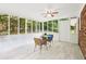 Charming sunroom featuring large windows, light wood flooring, a ceiling fan, and a cozy dining set for relaxation at 6000 Malibu Drive Dr, Morrow, GA 30260