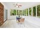 Inviting sunroom with large windows, light wood floors, ceiling fan, and table for enjoying the outdoor views at 6000 Malibu Drive Dr, Morrow, GA 30260
