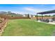 Spacious backyard with a well-manicured lawn, privacy fence, and a pergola with outdoor seating at 87 Rushing View Gln, Dallas, GA 30157
