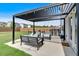 Back patio featuring an outdoor kitchen and dining area, covered by a stylish pergola with string lights at 87 Rushing View Gln, Dallas, GA 30157