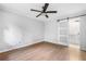 Bright bedroom featuring hardwood floors, white walls, a ceiling fan, and a barn door at 3068 Cherry Blossom Ln, Atlanta, GA 30344