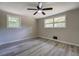 Bright bedroom features two windows, ceiling fan and modern gray wood-look floors at 4176 King Edward Dr, Douglasville, GA 30135