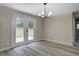 Dining room with modern light fixture, gray flooring, and sliding glass doors leading to yard at 4176 King Edward Dr, Douglasville, GA 30135