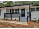 Inviting front porch featuring freshly painted white brick, a black front door, and newly landscaped beds at 4176 King Edward Dr, Douglasville, GA 30135