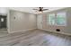 Spacious living room features a large window, a ceiling fan, and modern gray flooring at 4176 King Edward Dr, Douglasville, GA 30135