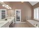 Sunlit bathroom with double sinks, large mirror and relaxing soaking tub at 5810 Old Mill Trce, Lithonia, GA 30038