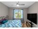 Bedroom featuring a blue chevron quilt, blue curtains, and a large TV at 5810 Old Mill Trce, Lithonia, GA 30038